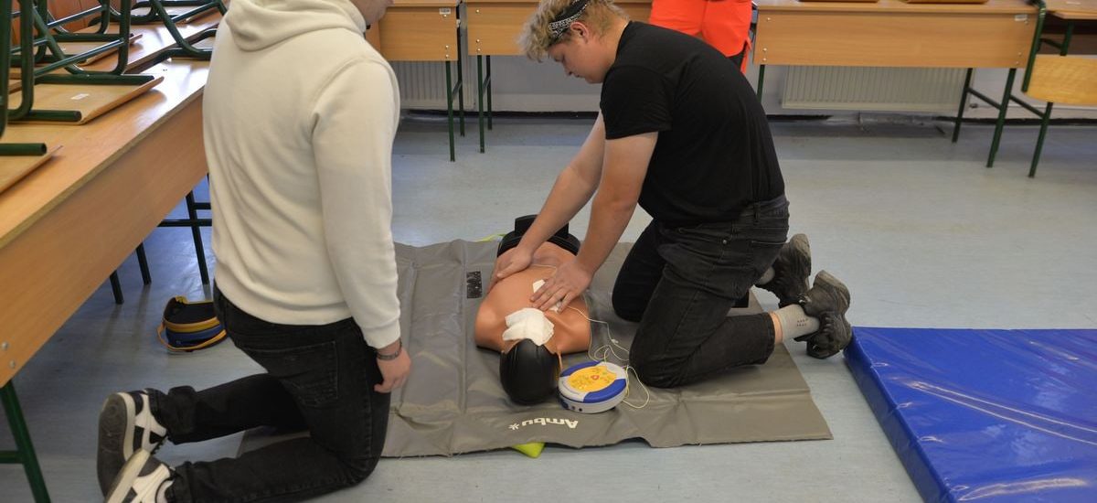 CPR training session with a dummy in a classroom environment.